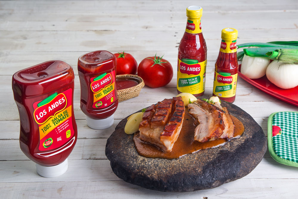 imagen de mesa servida con un plato de braceta de cerdo servido sobre una piedra junto a la salsa de tomate Los Andes